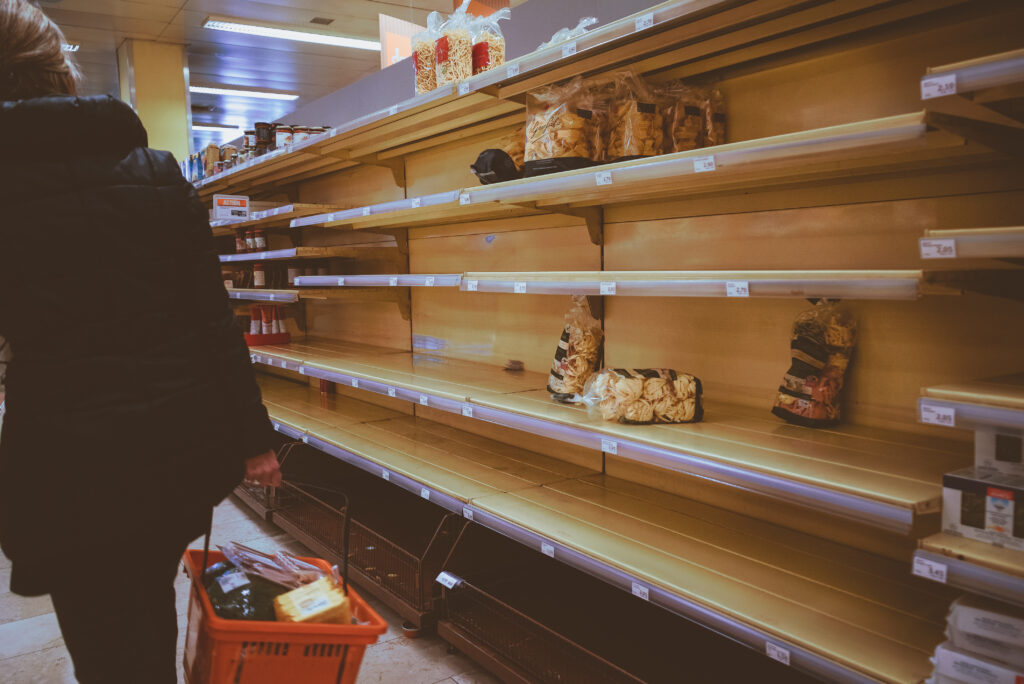 Customer facing empty supermarket shelves, illustrating on-shelf availability challenges in retail